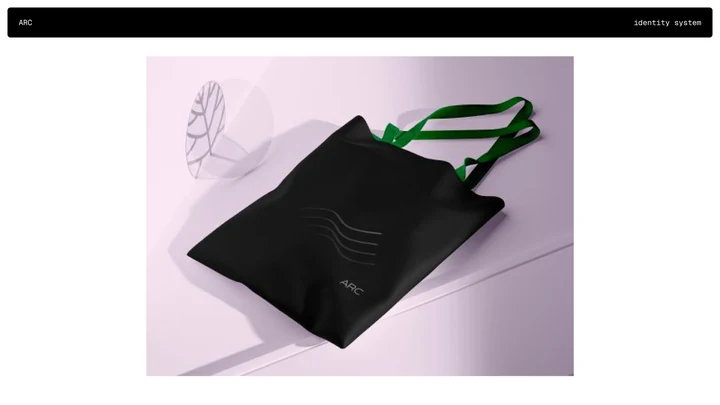 Black ARC tote bag with green handles and an embossed wave symbol